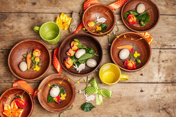 Easter ceramic bowls with eggs, bunnies, and fresh roses on a vintage table