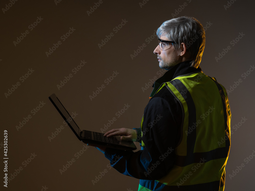 Poster geek in work uniform. man with a laptop on dark background. concept is an experienced geek. man with