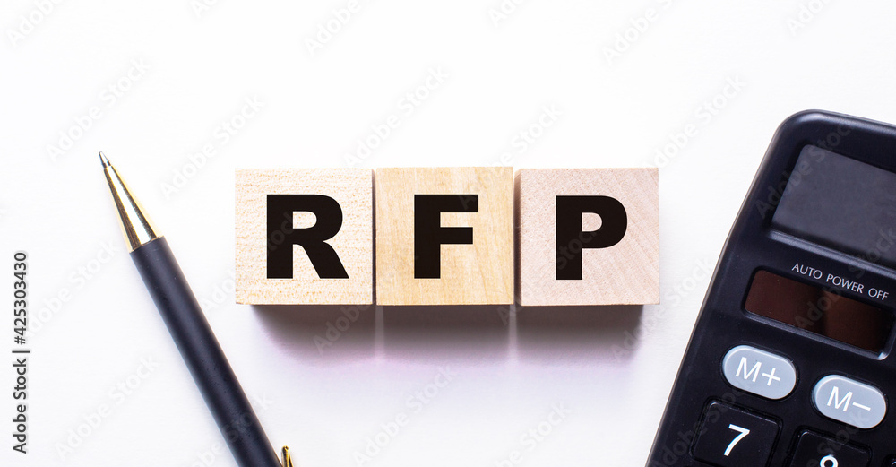 Poster the words rfp request for proposal is written on wooden cubes between a pen and a calculator on a li