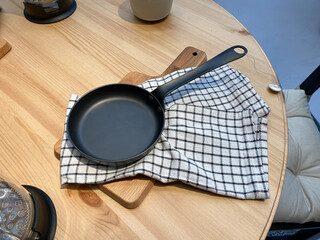 Empty cast iron skillet on wooden background