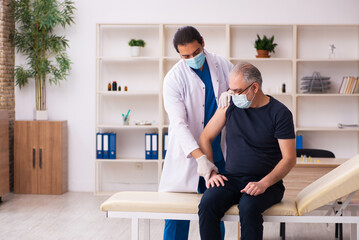 Old man visiting young doctor in covid-19 vaccination concept