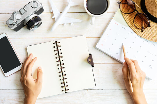 Young traveler planning a vacation trip and looking for holidays on the calendar, Travel concept