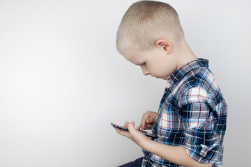 A child plays on a smartphone in a video game on a white background. The concept of child addiction...