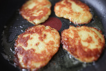 Cooking potato pancakes lie in frying pan