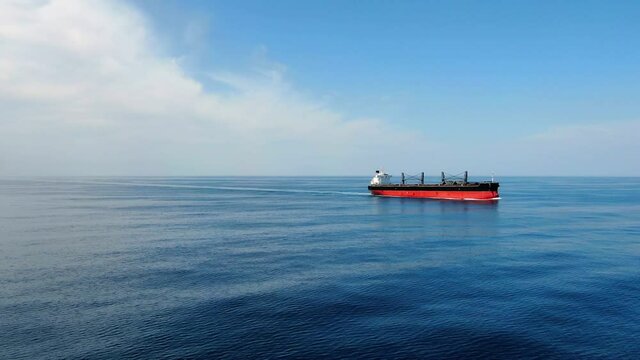 Large cargo ship. A bulk carrier carries cargo across the ocean. Transportation. Delivery. Logistics. A large ship for transporting. Aerial 4k shot.