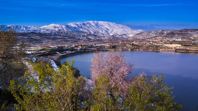 Beautiful winter dusk landscape at Lake Ram or Birkat el-Ram, a crater lake  in the northeastern Golan Heights, Israel, surrounded by snow-covered hills  and blossoming almond tree in the foreground Stock Photo | Adobe Stock
