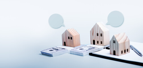 Wooden Small house, stacks of dollar bills and document file on sky blue background. Mortgage House loan concept