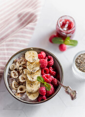 porridge with raspberries banana and nuts on coconut milk