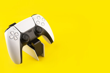 new generation of video wireless gamepads on the charger, yellow background © Анастасия Коровина