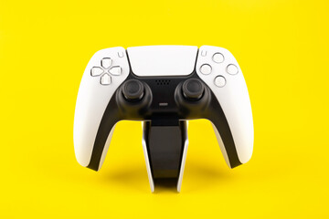 new generation of video wireless gamepads on the charger, yellow background © Анастасия Коровина