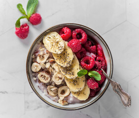 porridge with raspberries banana and nuts on coconut milk