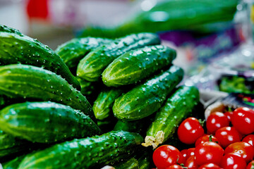 Cucumbers and tomatoes on the counter. Vegetable shop
