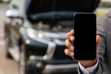 Blank screen of smartphone. Young businessman holding smartphone using application to call service and help car was broken down.