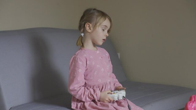 Little girl learning to play video games.