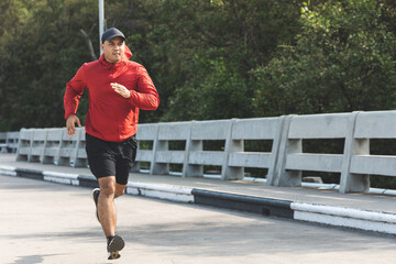 Young asian man wearing sportswear running outdoor. Portraits of Indian man jogging on the road....
