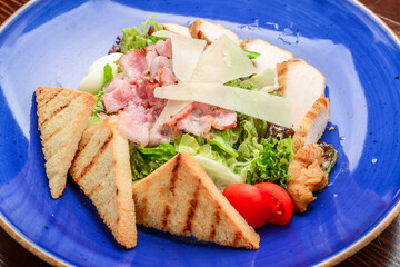 Chicken Caesar Salad. Caesar Salad with grilled chicken on plate. Grilled chicken breasts and fresh salad in plate