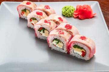 Salmon, tuna, sushi rolls set. On wooden background