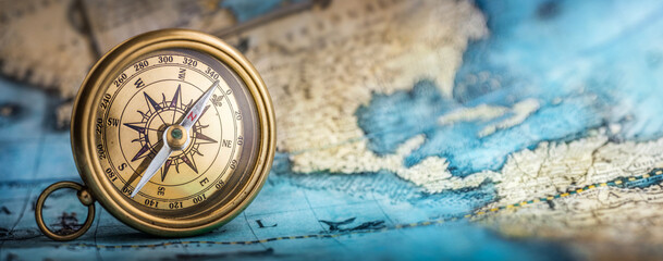 Magnetic old compass on world map.Travel, geography, navigation, tourism and exploration concept background. Macro photo. Very shallow focus.