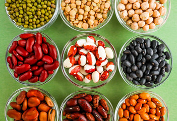 Collection of legumes in the cup isolated on green background