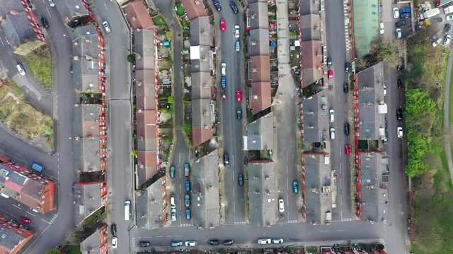 Top down aerial footage of the village of Armley in the city of Leeds West Yorkshire in the UK showing a straight down view of rows of terrace houses and residential estates in the spring time