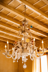Beautiful Murano glass crystal chandelier, under a wooden ceiling.