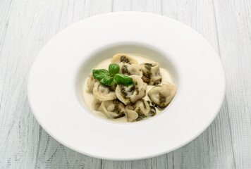 Meat dumplings, ravioli with meat with pesto sauce on plate