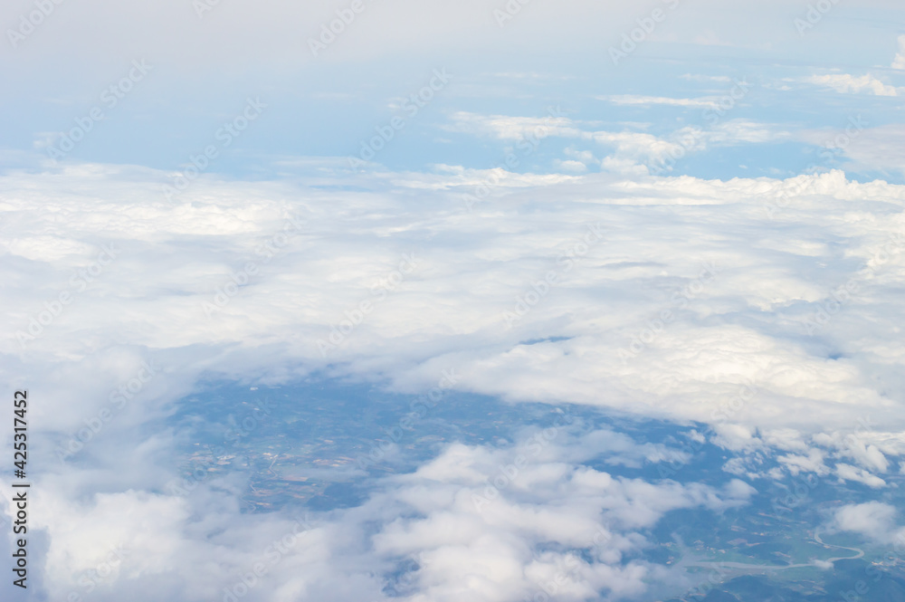 Wall mural over the clouds,blue sky with tiny clouds background beautiful natural view from airplane window abo