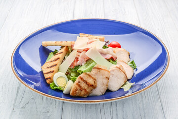 Chicken Caesar Salad. Caesar Salad with grilled chicken on plate. Grilled chicken breasts and fresh salad in plate