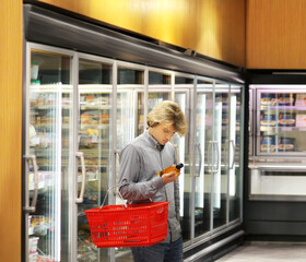 Man choosing frozen food from a supermarket freezer.
