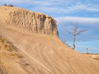 Early spring or winter over badlands with a lonely tree and windmill in Pawnee National Grassland in northern Colorado (Main Draw OHV Area)