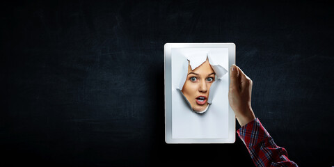 Naklejka premium Female face through the hole in paper
