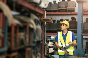 Asian male worker working to checking products stock inventory at warehouse shelf