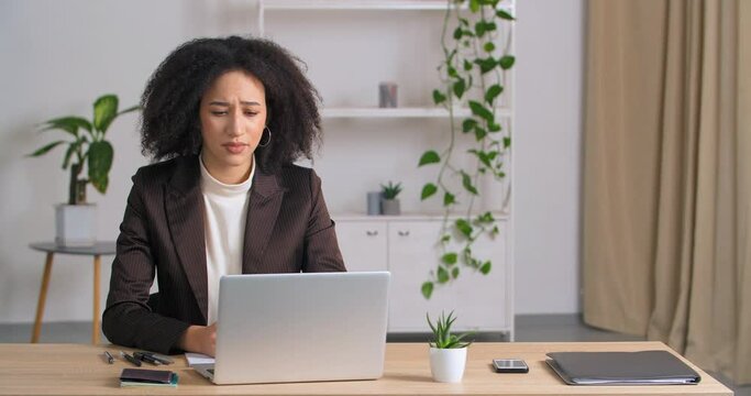Stressed afro american businesswoman annoyed using laptop reading bad newa about lock down angry ethnic frelancer lady mad with computer problem frustrated with data loss online mistake system failure