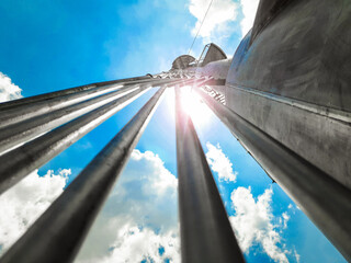 Close-up view from below to the top of flare stack tower in LNG facility on cloudy day