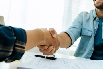 engineer, architect, construction worker team hands shaking after plan project contract on workplace desk in meeting room office at construction site, contractor, partnership, construction concept