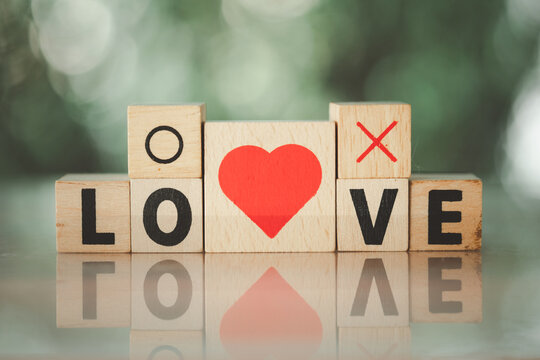 Love message written in wooden blocks with red heart shape and yes or no symbol.