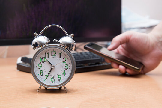 Working hours.Concept.Watch the alarm clock next to the computer.