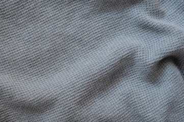 Fototapeta na wymiar Texture of a woolen knitted gray blue sweater. Fabric background.