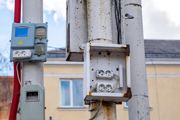 Electrical outlets for current on a pole in the open air.