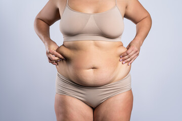Tummy tuck, flabby skin on a fat belly, plastic surgery concept