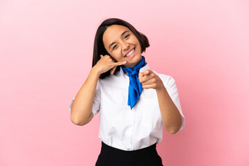 Airplane stewardess over isolated background making phone gesture and pointing front