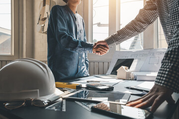 Architect shaking hands with clients to achieve agreement to work together at the office.