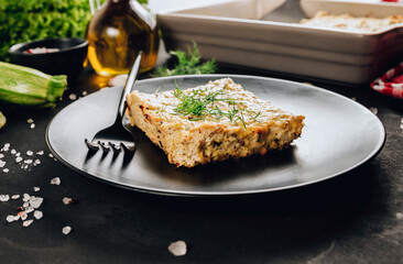 Zucchini casserole on dark background. Dietary, low-calorie, healthy food. Homemade Casserole from squash with chicken and eggs.
