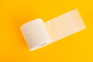white toilet paper on a bright isolated yellow background. Photo