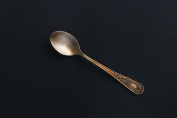 Old silver teaspoon on a black background. Vintage. Grunge. Photo