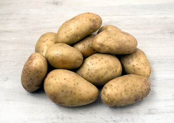 fresh organic potatoes on wooden table