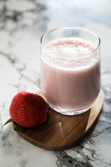 Indian traditional lassi drink with strawberries on a light background