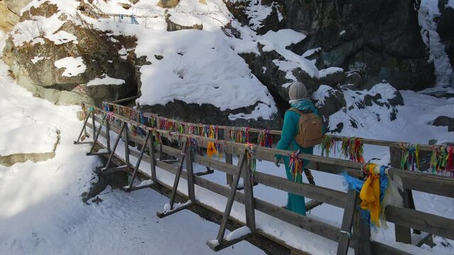 Female Tourist Walking across Wooden Bridge in Tunkinsky National Park near Arshan, Buryatia, Russia