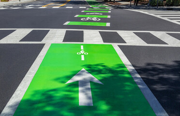Bicycle path and pedestrian crossing, colorful road markings on the asphalt, bright light green...