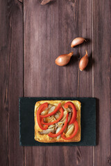 Traditional Spanish pizza coca on the shale board on brown background